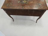 a small wooden table with a floral design on it