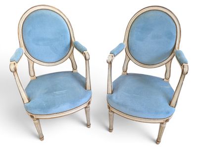 pair of blue upholstered chairs with arms and legs