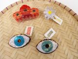 three different types of eye shaped brooches sitting on a tray