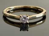 a close up of a diamond ring on a reflective surface