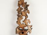 an image of a wooden sculpture on a wall with a bird on it