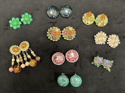 several pairs of earrings are displayed on a black surface