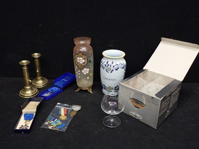 une boîte contenant une bougie, un vase, un bougeoir et quelques autres objets posés sur une table