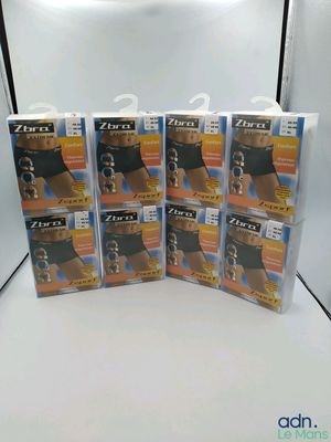 Quatre paquets de sous-vêtements pour hommes sont posés sur une surface blanche
