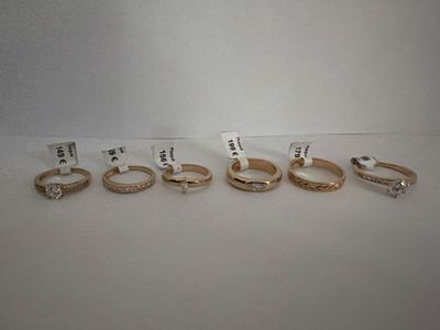 five different rings are shown in a row on a white surface