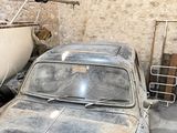a old car parked next to a boat in a garage