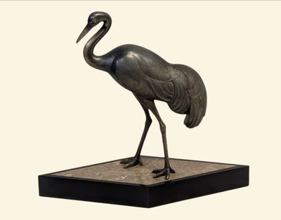 une statue représentant une grue posée sur un socle