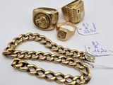 a group of gold rings and bracelets on a white surface