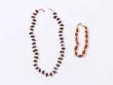 two necklaces and a bracelet on a white surface
