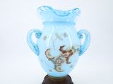 a blue vase with a dragon on it on a wooden stand