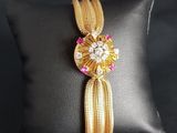 a close up of a cushion with a gold bracelet on it