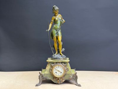 a statue of a woman holding a clock on top of a table