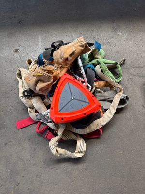 a pile of shoes on the ground next to a skateboard