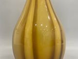 a brown and yellow vase sitting on a white surface