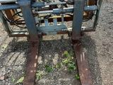 a close up of a forklift sitting on top of a gravel field