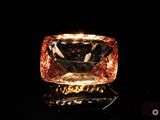 a close up of a pink diamond on a black surface
