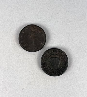 deux vieilles pièces posées sur une surface blanche