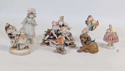 cinq figurines représentant des personnes et un chien, posées sur une surface blanche