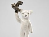 statue d'un ours polaire tenant un oiseau dans sa patte