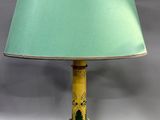 yellow and green table lamp with a green shade on top of it