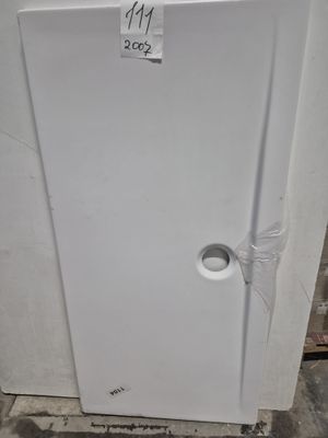 un réfrigérateur blanc sur lequel est collé un autocollant, dans une pièce