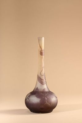 purple and white vase with a wooden handle sitting on a beige surface