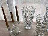 three glass vases and a candle holder on a window sill