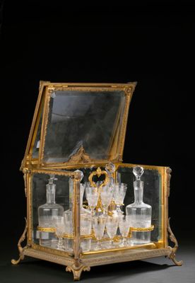 a gold and glass box with a lot of bottles inside of it