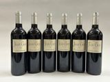 six bouteilles de vin rouge sont alignées
