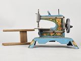 une petite machine à coudre posée à côté d'une table en bois