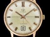 un gros plan d'une montre-bracelet en or sur fond noir