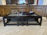 a coffee table with a glass top in front of a flat screen tv