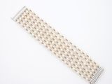 un gros plan d'un bracelet blanc orné de perles sur fond blanc