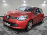 une voiture rouge est garée dans une pièce au sol en damier