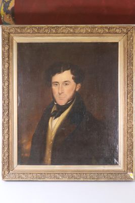 portrait of a man in a black coat in a gold frame on a red wall