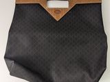 un sac à main noir avec une anse marron sur un fond blanc