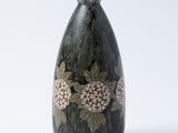 un vase noir orné de fleurs sur fond blanc