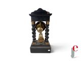 a clock that is sitting on a stand on a white surface