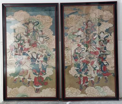 two framed paintings of oriental figures on a wall in a room
