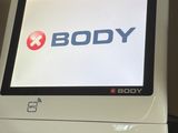 un écran d'ordinateur posé sur un bureau, avec le logo « Body » affiché à l'écran