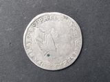 un gros plan d'une pièce de monnaie sur laquelle est sertie une pierre verte