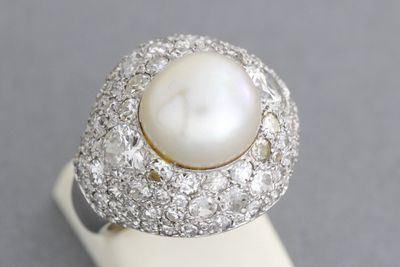 Bague en platine ornée d’une perle épaulée de deux diamants …
