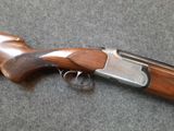 a close up of a shotgun with a wooden handle on a gray surface