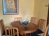 une table et des chaises dans une pièce où est accroché un tableau au mur