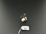 a close up of a tag on a table with a ring on it