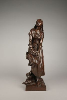 une statue antique en bronze représentant une femme tenant un enfant dans ses bras