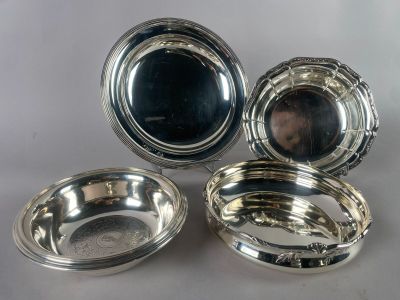 three silverplated dishes on a table with a mirror in the background