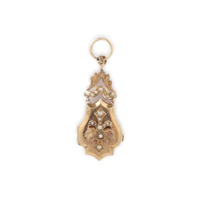 un gros plan d'un pendentif plaqué or orné d'un motif floral