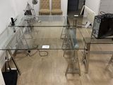 une table en verre sur laquelle est posé un ordinateur portable, dans une pièce