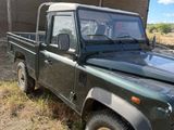 a green truck that is parked in the grass